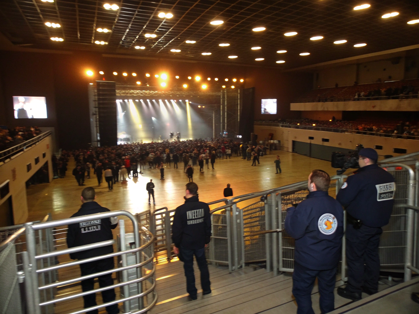 Live concert arena with orderly spectator lighting and stage visibility