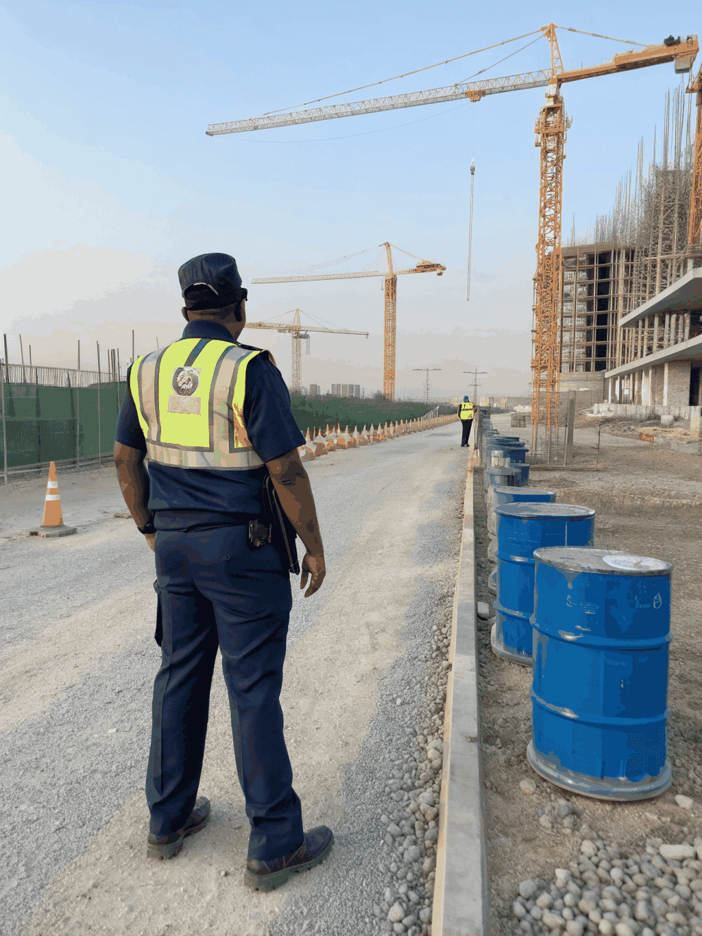 Security officer in black uniform documenting a scheduled fire watch patrol at a commercial property